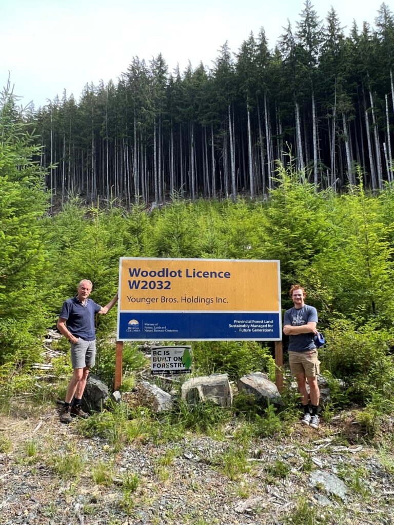 woodlot licensee and son in front of woodlot sign